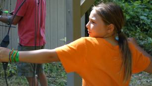 A young woman participating in archery